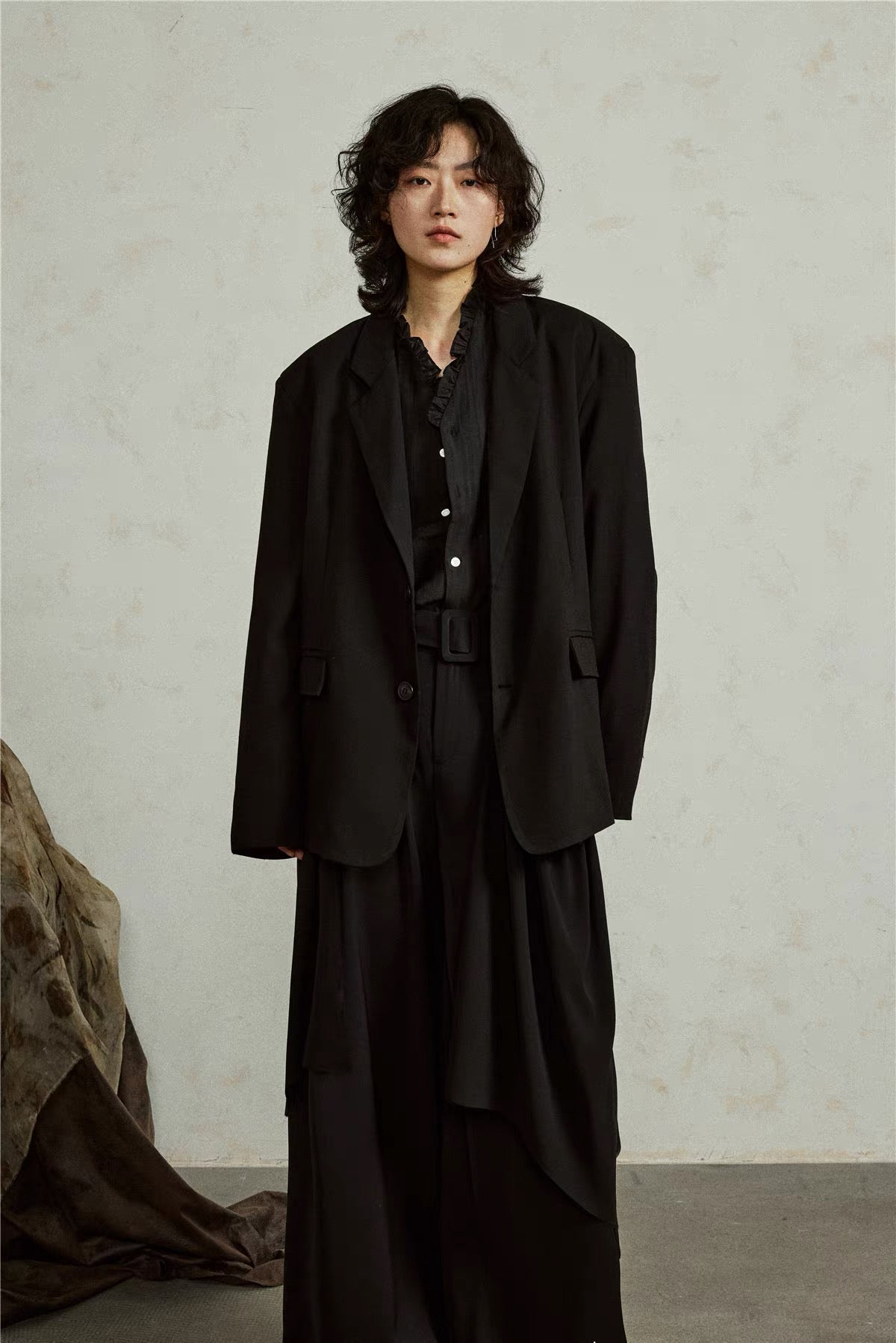 Black detachable hem blazer, front view showing the draped panel beneath the tailored jacket