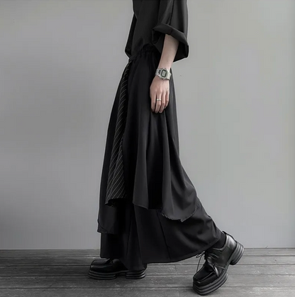 Dark avant-garde layered hakama pants – asymmetric hem in motion – side view